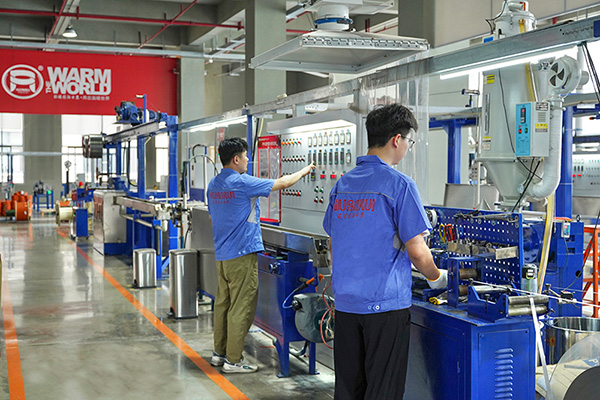 工人在操作电伴热带护套挤出设备。 环瑞电热供图